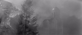 Movie still from “Andrei Rublev” (1966), directed by Andrei Tarkovsky – Smoke billows from a church in the middle of a forest; Extreme Wide shot, Low angle