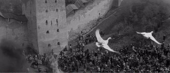 Movie still from “Andrei Rublev” (1966), directed by Andrei Tarkovsky – A bird is flying over a crowd of people; Extreme Wide shot, High angle