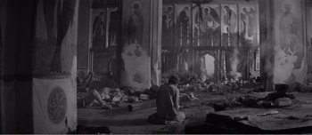 Movie still from “Andrei Rublev” (1966), directed by Andrei Tarkovsky – A man sitting on the ground in front of an altar; Wide shot, High angle