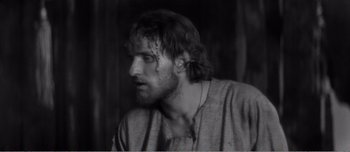 Movie still from “Andrei Rublev” (1966), directed by Andrei Tarkovsky – Black and white photograph of a man with wet hair; Close Up shot, High angle