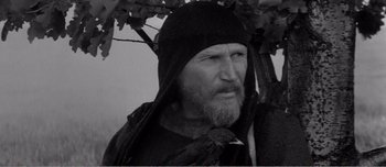 Movie still from “Andrei Rublev” (1966), directed by Andrei Tarkovsky – An old man with a beard and a bird on a branch; Close Up shot, Low angle