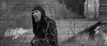 Movie still from “Andrei Rublev” (1966), directed by Andrei Tarkovsky – An old man with a long beard and a hooded jacket; Medium shot, Low angle