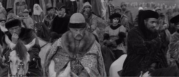 Movie still from “Andrei Rublev” (1966), directed by Andrei Tarkovsky – An old photo of a man wearing a fur coat; Medium shot, High angle