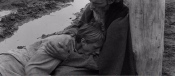 Movie still from “Andrei Rublev” (1966), directed by Andrei Tarkovsky – An old man holding a young girl in his arms; Close Up shot, High angle