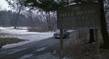 Movie still from “Angel Heart” (1987), directed by Alan Parker – A car driving down a road next to trees; Extreme Wide shot, High angle