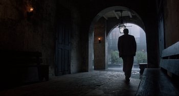 A man walking through an archway in the dark