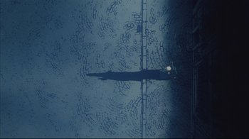 Movie still from “Angel's Egg” (1985), directed by Mamoru Oshii – An aerial view of a person standing on a bridge; Extreme Wide shot, Overhead angle