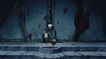 Movie still from “Angel's Egg” (1985), directed by Mamoru Oshii – An old man sitting on the ground in front of a wall; Wide shot, High angle