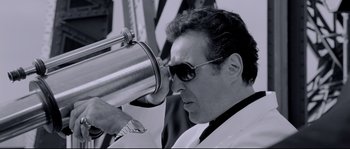Movie still from “Angel-A” (2005), directed by Luc Besson – A man with sunglasses looking through a telescope; Close Up shot, Low angle