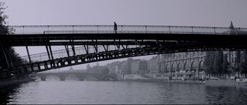 Movie still from “Angel-A” (2005), directed by Luc Besson – A person standing on a bridge over a body of water; Extreme Wide shot, Low angle