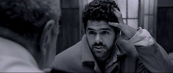 Movie still from “Angel-A” (2005), directed by Luc Besson – A black and white photo of a man with a beard; Close Up shot, Over the shoulder angle