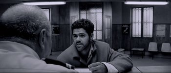 Movie still from “Angel-A” (2005), directed by Luc Besson – Black and white photograph of a man looking at a piece of paper; Close Up shot, Over the shoulder angle