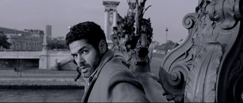 Movie still from “Angel-A” (2005), directed by Luc Besson – A black and white photo of a man on a motorcycle; Medium shot, Low angle