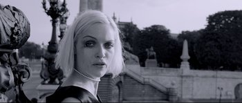 Movie still from “Angel-A” (2005), directed by Luc Besson – A black and white photo of a woman in a black dress; Close Up shot, Low angle