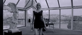 Movie still from “Angel-A” (2005), directed by Luc Besson – A woman in a black dress standing in front of a window; Wide shot, Low angle