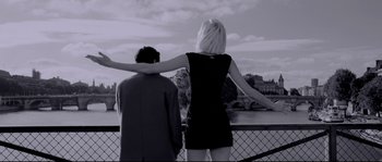Movie still from “Angel-A” (2005), directed by Luc Besson – A man and a woman standing next to each other on a bridge; Medium shot, Low angle