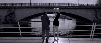 Movie still from “Angel-A” (2005), directed by Luc Besson – A man and a woman standing next to each other on a bridge; Wide shot, Low angle