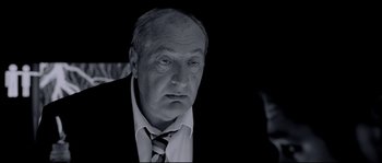 Movie still from “Angel-A” (2005), directed by Luc Besson – An older man wearing a suit and tie looking at the camera; Close Up shot, Low angle