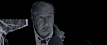 Movie still from “Angel-A” (2005), directed by Luc Besson – An older man holding his arm up to his face; Close Up shot, Low angle