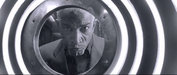 Movie still from “Angel-A” (2005), directed by Luc Besson – A black - and - white photo of a man looking into a mirror; Extreme Close Up shot, Low angle