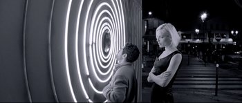 Movie still from “Angel-A” (2005), directed by Luc Besson – A man and a woman standing in front of a wall; Medium shot, Low angle