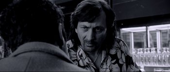 Movie still from “Angel-A” (2005), directed by Luc Besson – A black and white photo of a man with long hair; Close Up shot, Over the shoulder angle