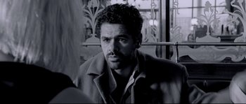 Movie still from “Angel-A” (2005), directed by Luc Besson – Black and white photograph of a man with a beard; Close Up shot, Over the shoulder angle