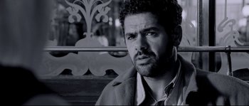 Movie still from “Angel-A” (2005), directed by Luc Besson – Black and white photograph of a man looking at the camera; Close Up shot, Low angle