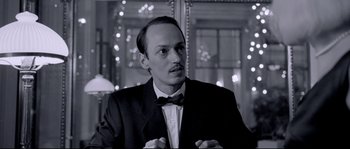 Movie still from “Angel-A” (2005), directed by Luc Besson – A black and white photo of a man wearing a suit and bow tie; Close Up shot, Low angle