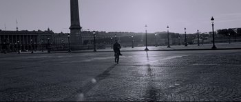 Movie still from “Angel-A” (2005), directed by Luc Besson – A man walking on a street with a pole in the background; Wide shot, Low angle