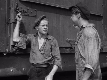 Movie still from “Angels with Dirty Faces” (1938), directed by Michael Curtiz – Two young men are standing next to each other talking; Medium shot, High angle