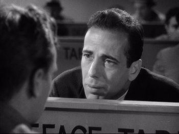 Movie still from “Angels with Dirty Faces” (1938), directed by Michael Curtiz – A black - and - white photo of a man talking to another man; Close Up shot, Over the shoulder angle