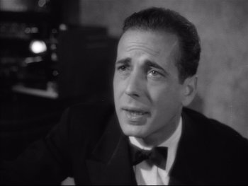 Movie still from “Angels with Dirty Faces” (1938), directed by Michael Curtiz – A man in a suit and bow tie looking sad; Close Up shot, High angle