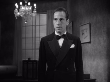 Movie still from “Angels with Dirty Faces” (1938), directed by Michael Curtiz – A black and white photo of a man in a tuxedo; Medium shot, Low angle