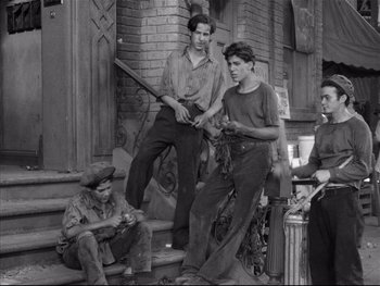 Movie still from “Angels with Dirty Faces” (1938), directed by Michael Curtiz – A black and white photo of a group of men on steps; Wide shot, Low angle