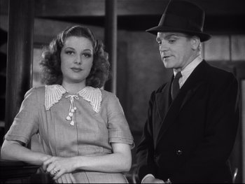 Movie still from “Angels with Dirty Faces” (1938), directed by Michael Curtiz – A man and a woman standing next to each other; Medium shot, Low angle