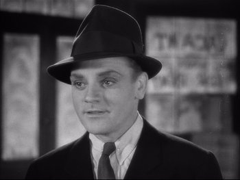 Movie still from “Angels with Dirty Faces” (1938), directed by Michael Curtiz – A black and white photo of a man in a suit and hat; Close Up shot, Low angle