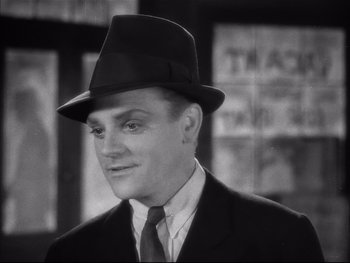 Movie still from “Angels with Dirty Faces” (1938), directed by Michael Curtiz – A black and white photo of a man in a suit and hat; Close Up shot, High angle