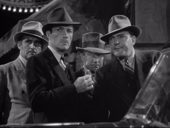 Movie still from “Angels with Dirty Faces” (1938), directed by Michael Curtiz – A black and white photo of a group of men in suits and hats; Medium shot, Low angle