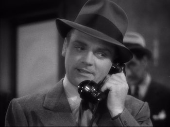 Movie still from “Angels with Dirty Faces” (1938), directed by Michael Curtiz – A black and white photo of a man talking on a phone; Close Up shot, High angle