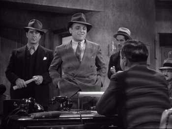 Movie still from “Angels with Dirty Faces” (1938), directed by Michael Curtiz – A group of men standing next to each other in front of a counter; Medium shot, Low angle