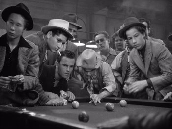 Movie still from “Angels with Dirty Faces” (1938), directed by Michael Curtiz – A black and white photo of a group of men playing pool; Medium shot, High angle