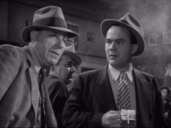 Movie still from “Angels with Dirty Faces” (1938), directed by Michael Curtiz – A black - and - white photo of two men in hats and ties; Medium shot, Low angle