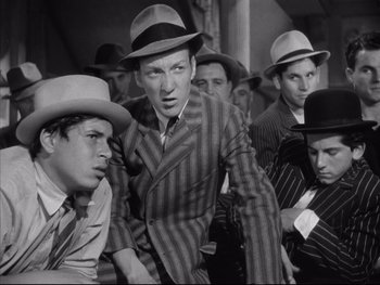 Movie still from “Angels with Dirty Faces” (1938), directed by Michael Curtiz – A black and white photo of a group of men wearing hats; Medium shot, Low angle