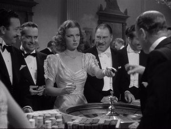 Movie still from “Angels with Dirty Faces” (1938), directed by Michael Curtiz – A group of people standing in front of a roulette table; Medium shot, Over the shoulder angle