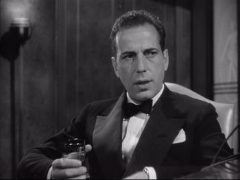 Movie still from “Angels with Dirty Faces” (1938), directed by Michael Curtiz – A man in a tuxedo holding a glass of wine; Close Up shot, Low angle