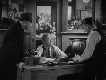 Movie still from “Angels with Dirty Faces” (1938), directed by Michael Curtiz – A group of men sitting at a table in a room; Medium shot, Over the shoulder angle