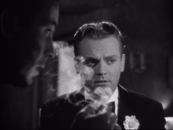 Movie still from “Angels with Dirty Faces” (1938), directed by Michael Curtiz – A man smoking a cigarette in front of another man in a suit; Close Up shot, Over the shoulder angle