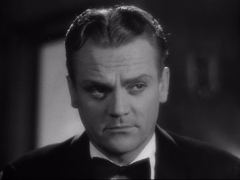 Movie still from “Angels with Dirty Faces” (1938), directed by Michael Curtiz – A man in a suit and bow tie; Close Up shot, Over the shoulder angle