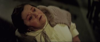 Movie still from “Anguish” (1987), directed by Bigas Luna – An older woman laying in a bed with her eyes closed; Close Up shot, High angle